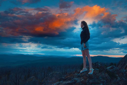 Travel, lesure and freedom concept - woman on the top of Altai mountain, summer fantastic sunset