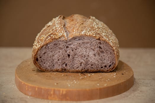 unusual craft bread with lilac-colored pulp on a brown background and wooden board