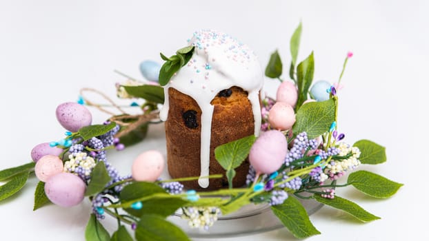Easter cake in the center of a wreath of spring flowers on a white background