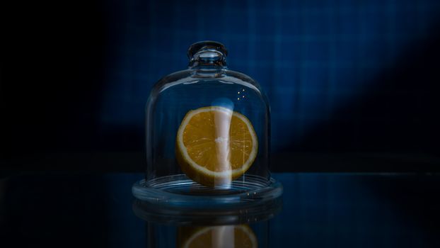 Half lemon in a glass jar on a dark blue background