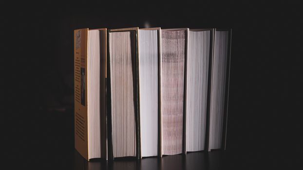 messy stack of books on a black background