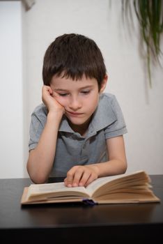 A boy without expressed interest reads a book