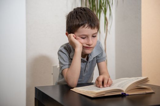 A boy without expressed interest reads a book