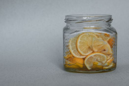 Sweet dessert of thinly sliced lemon with sugar in a glass jar