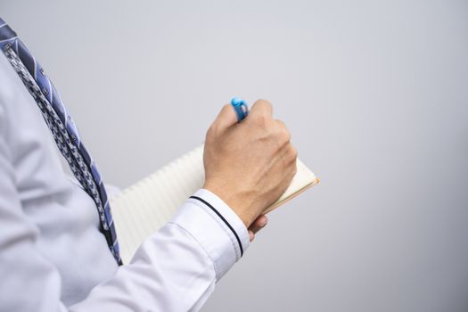 A business person is holding a pen and notes on the assignment