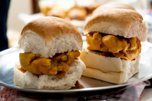 Selective focus macro shot of vada pav a fried potato in small buns a popular street food snack in mumbai India . Shows home made recipies for easy tasty and delicious street food for home