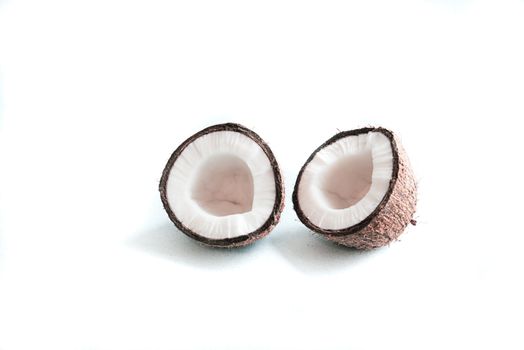 two halves of coconut on a white background with copy spece