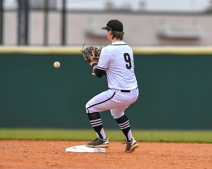 Action photo of high school baseball players making amazing plays during a baseball game