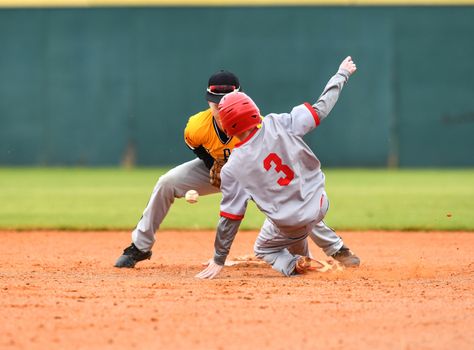 Action photo of high school baseball players making amazing plays during a baseball game