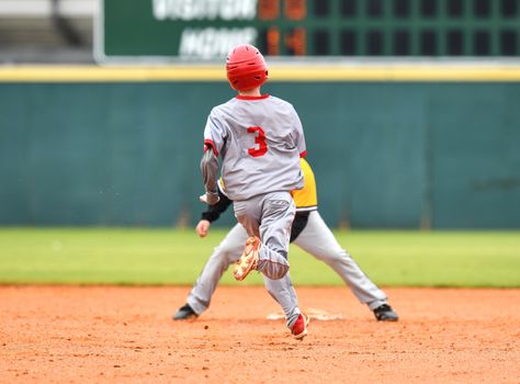 Action photo of high school baseball players making amazing plays during a baseball game