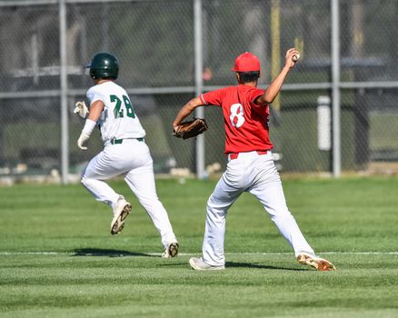 Action photo of high school baseball players making amazing plays during a baseball game