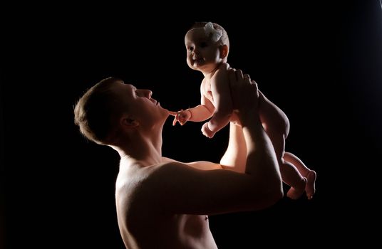 Male holding nice infant baby girl. Daughter on father's arms. Human growth and development. New generation. Cheerful man and his baby. New life concept. Silhouette