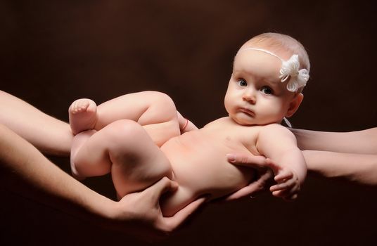 Male and female holding nice infant baby girl. Daughter on father's and mother's arms. Human growth and development. New generation. New life concept