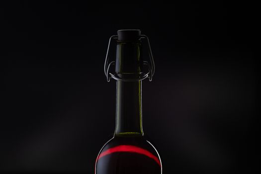 Rose wine. Red wine in bottle and metal opener on cork. Dark background. Silhouette
