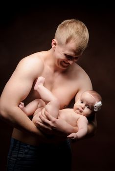 Male holding nice infant baby girl. Daughter on father's arms. Human growth and development. New generation. Cheerful man and his baby. New life concept