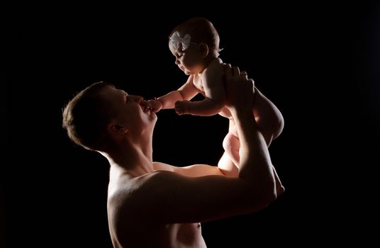 Male holding nice infant baby girl. Daughter on father's arms. Human growth and development. New generation. Cheerful man and his baby. New life concept. Silhouette