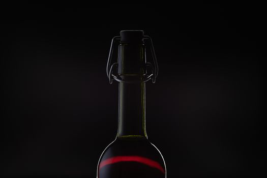 Rose wine. Red wine in bottle and metal opener on cork. Dark background. Silhouette