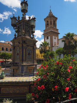 Monumental colorful tiled fountain at the center of the the Plaza Alta with the Iglesia de Nuestra Senora de la Palma, or The Church of Our Lady of the Palm, Algeciras, Andalucia, Spain