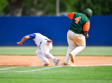 Action photo of high school baseball players making amazing plays during a baseball game