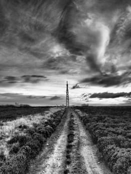 Transmitter mast viewed from Howdale Moor under dark menacing brooding sky shot in black and white in the North York Moors National Park, Yorkshire, UK