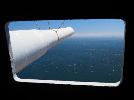 Looking down a gun barrel from the sighting window from the battery emplacement across the Strait of Gibraltar with the coast of Morocco in the distance.