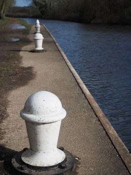 White mooring bollards perfectly in line ready for canal boats at Padworth Lock, Kennet and Avon Canal, Berkshire, UK