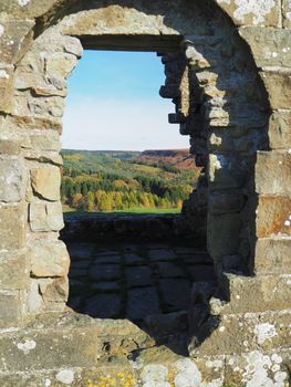View through a window of the ruins of Skelton Tower near Levisham on a bright, sunny autumn day with views over North York Moors National Park, Yorkshire, UK