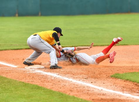 Action photo of high school baseball players making amazing plays during a baseball game