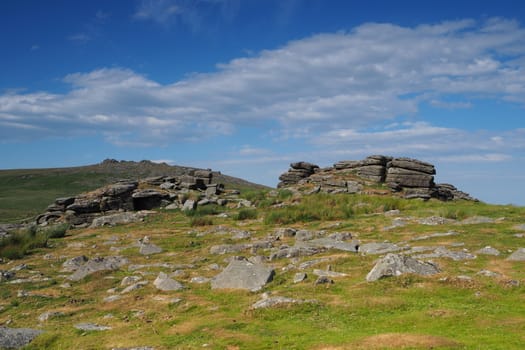 View from Rowtor with West Mill Tor in the background with white clouds in a blue sky, Dartmoor National Park, Devon, UK