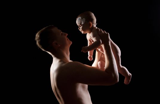 Male holding nice infant baby girl. Daughter on father's arms. Human growth and development. New generation. Cheerful man and his baby. New life concept. Silhouette