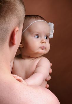 Male holding nice infant baby girl. Daughter on father's shoulders. Human growth and development. New generation. Cheerful man and his baby. New life concept