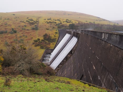 Water flowing over Meldon Dam with wind whipping up spray, Meldon Reservoir, Dartmoor National Park, Devon, UK