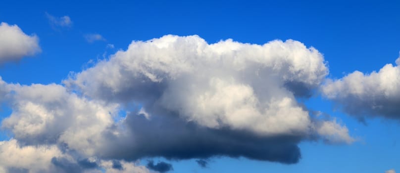 Beautiful fluffy white beautiful cloud formations in a deep blue summer sky