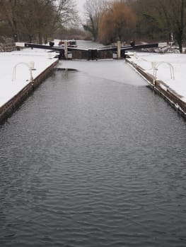 Winter snow with icy water in Padworth Lock, Kennet and Avon Canal, Berkshire, UK