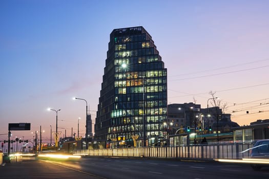 Street with evening car traffic and modern buildings in Poznan