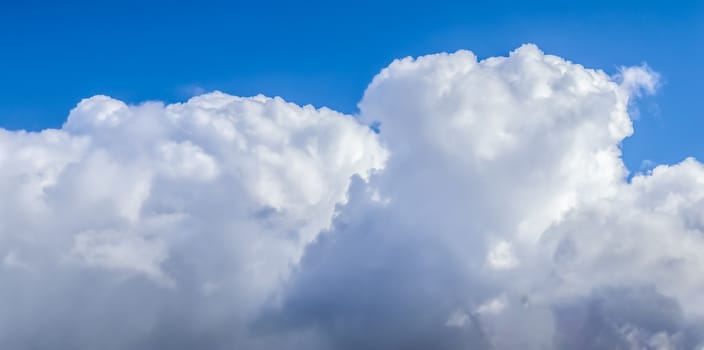 Beautiful fluffy white beautiful cloud formations in a deep blue summer sky