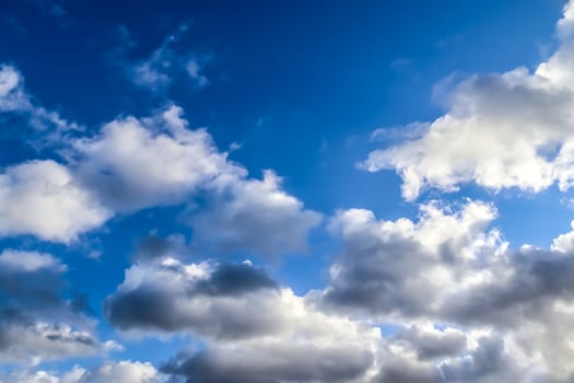 Beautiful fluffy white beautiful cloud formations in a deep blue summer sky