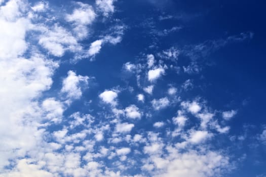 Beautiful fluffy white beautiful cloud formations in a deep blue summer sky