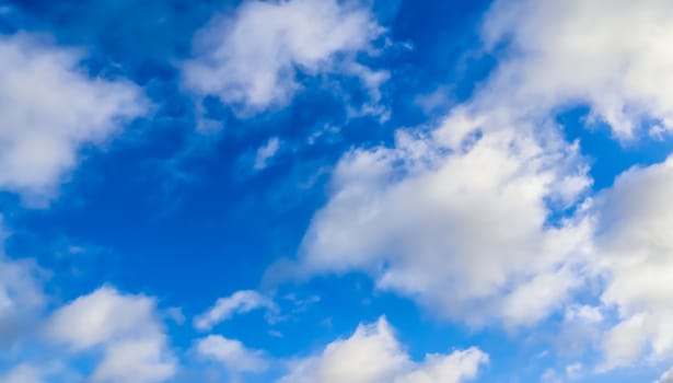 Beautiful fluffy white beautiful cloud formations in a deep blue summer sky