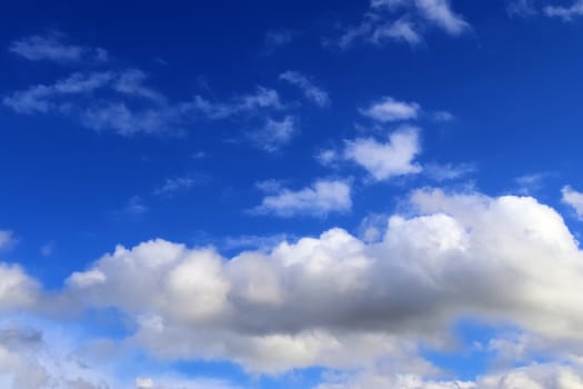 Beautiful fluffy white beautiful cloud formations in a deep blue summer sky