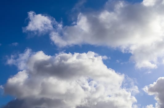 Beautiful fluffy white beautiful cloud formations in a deep blue summer sky