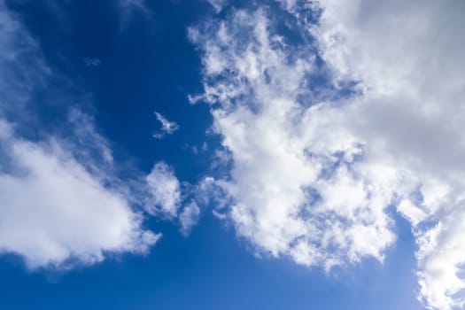 Beautiful fluffy white beautiful cloud formations in a deep blue summer sky