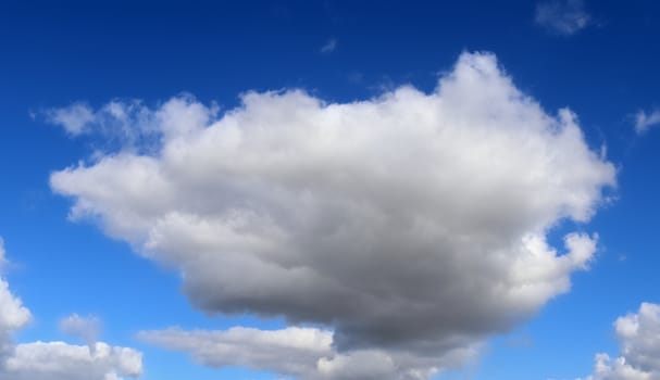 Beautiful fluffy white beautiful cloud formations in a deep blue summer sky