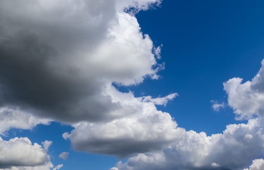 Beautiful fluffy white beautiful cloud formations in a deep blue summer sky