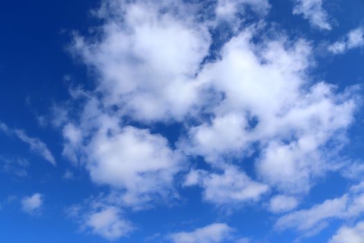 Beautiful fluffy white beautiful cloud formations in a deep blue summer sky