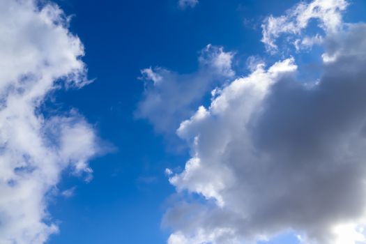 Beautiful fluffy white beautiful cloud formations in a deep blue summer sky