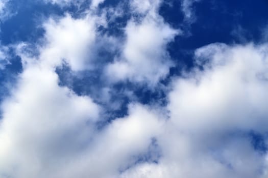 Beautiful fluffy white beautiful cloud formations in a deep blue summer sky