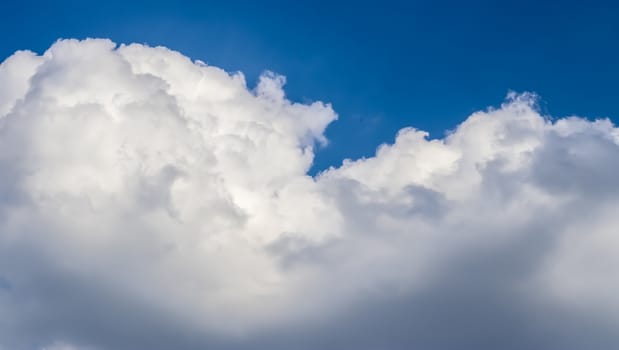 Beautiful fluffy white beautiful cloud formations in a deep blue summer sky