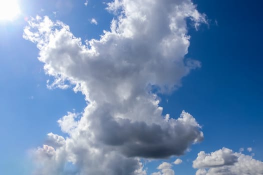 Beautiful fluffy white beautiful cloud formations in a deep blue summer sky