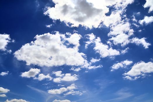 Beautiful fluffy white beautiful cloud formations in a deep blue summer sky